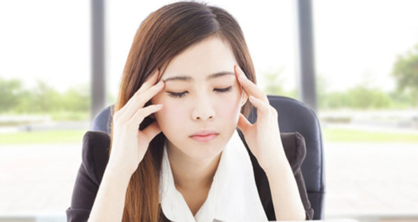 Woman holding her head due to stress.