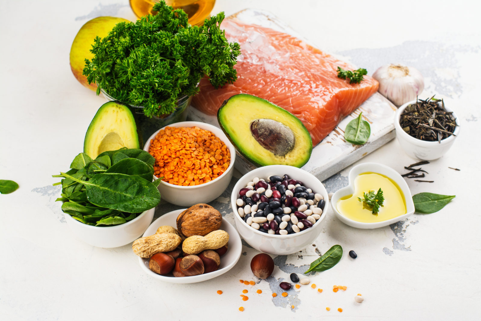 a sampling of healthy foods, including salmon, avocado, spinach, nuts and berries